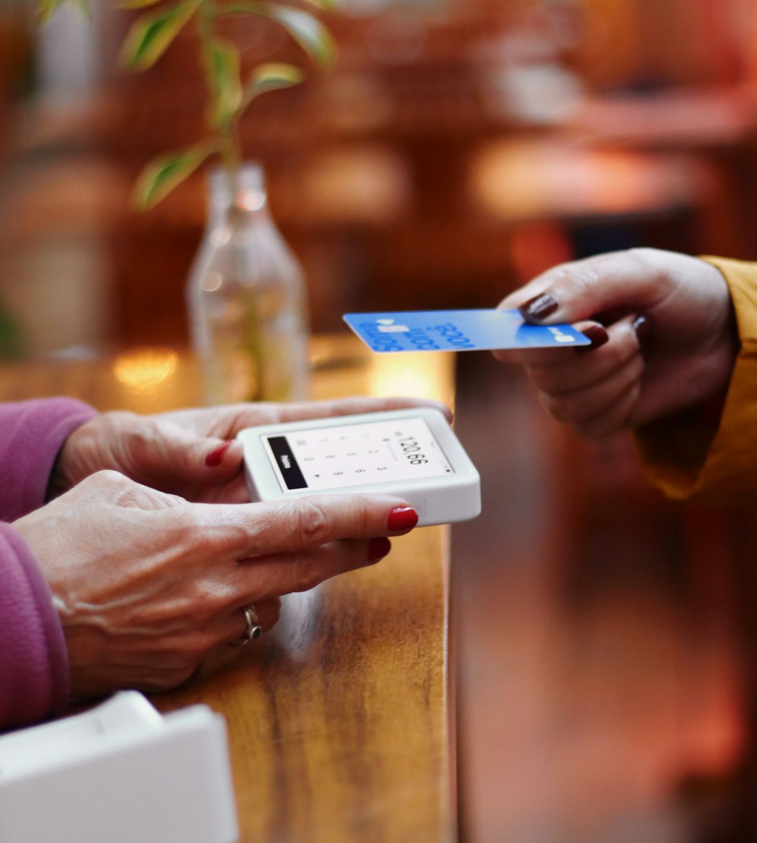 A guest paying by contactless card at a bar