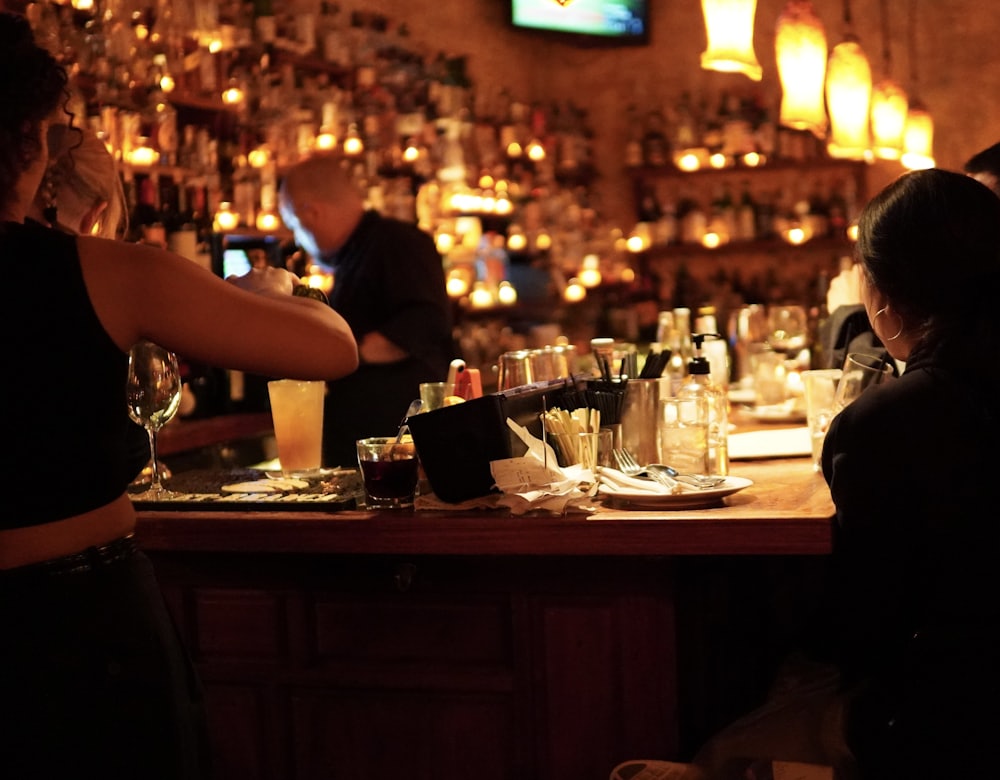 Guests at a busy bar counter in the evening